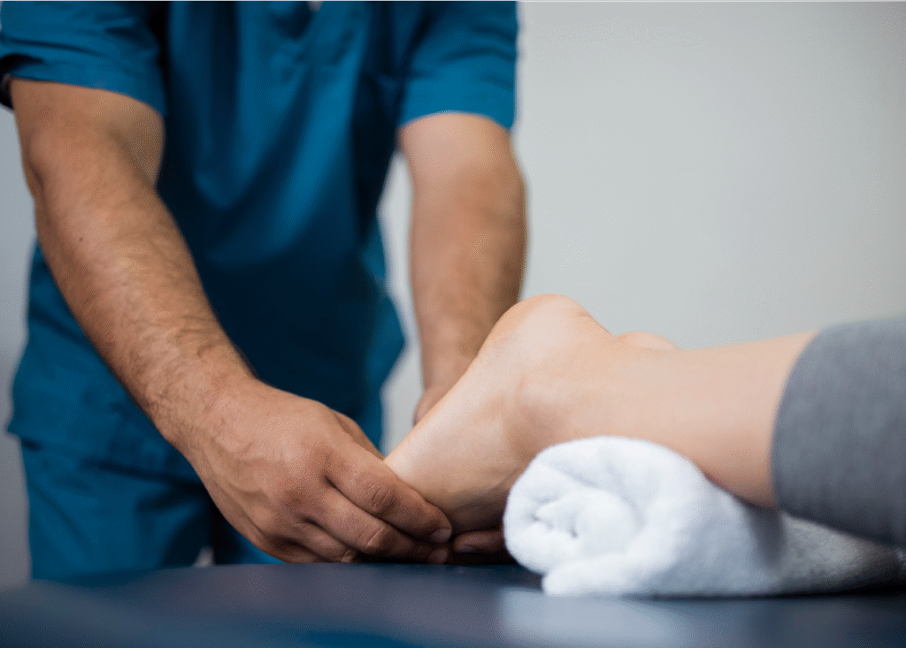 Doctor especialista masajeando los pies de una mujer recostada