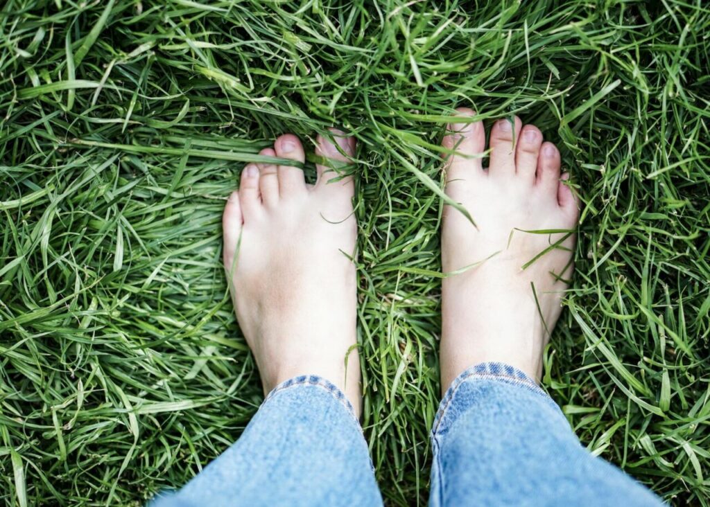 Pies descalzos sobre grama larga